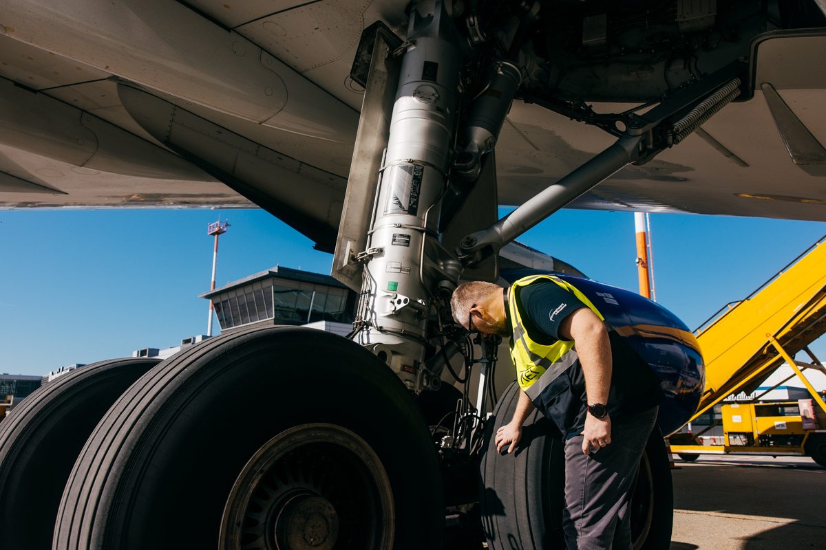 Technician inspecting aircraft landing gear