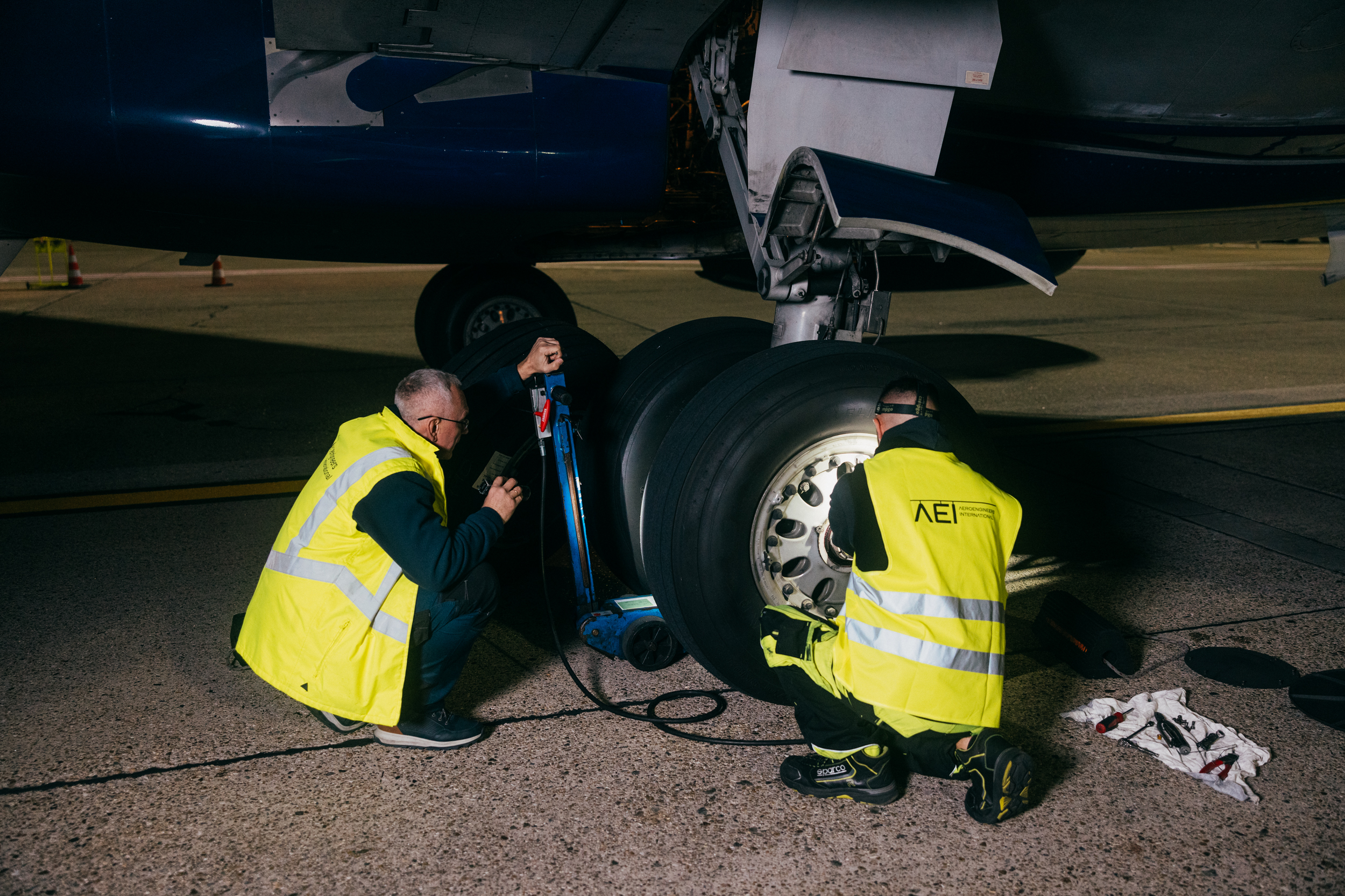 Two AEI technicians working together on aircraft landing gear